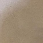 A close up of the surface of a beige colored wall.