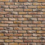 A brick wall with some brown and red bricks